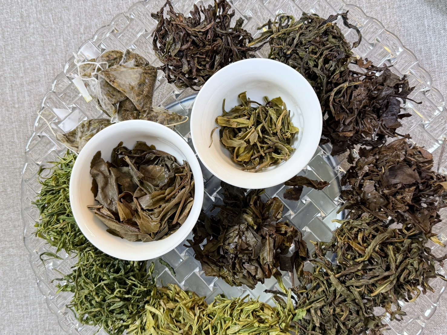 ガラス皿に並べた色や形の異なる茶葉